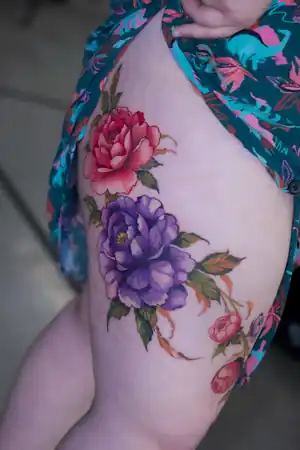 Colour peony thigh tattoo by Kristina Vishar