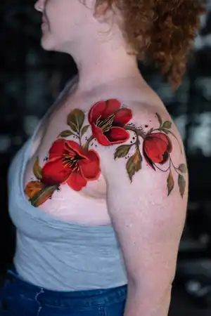 Red floral shoulder tattoo by Kristina Vishar