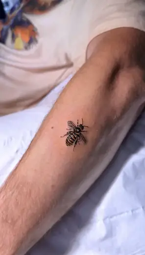 Miniature bee forearm tattoo by Kristina Vishar