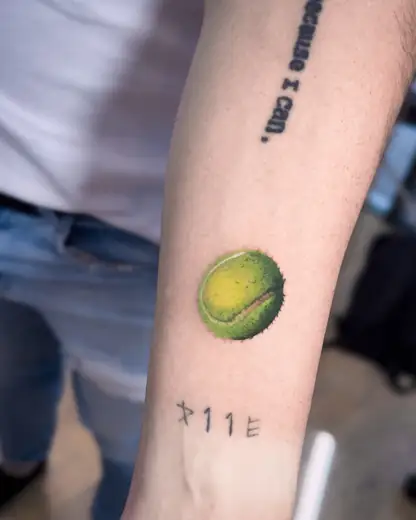 Tiny tennis ball colour tattoo by Kristina Vishar